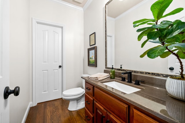 bathroom featuring ornamental molding, wood-type flooring, vanity, and toilet