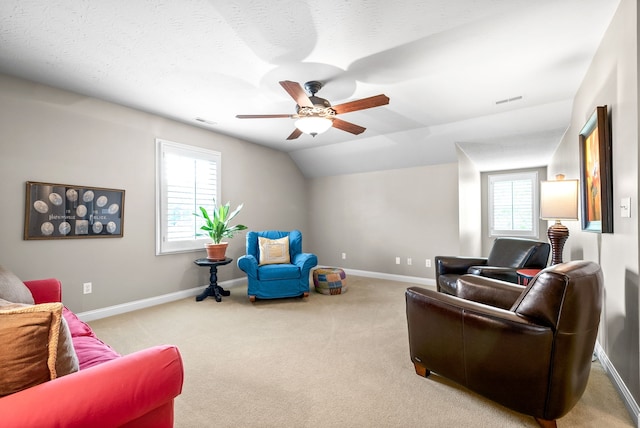 carpeted living room with lofted ceiling, ceiling fan, a healthy amount of sunlight, and a textured ceiling