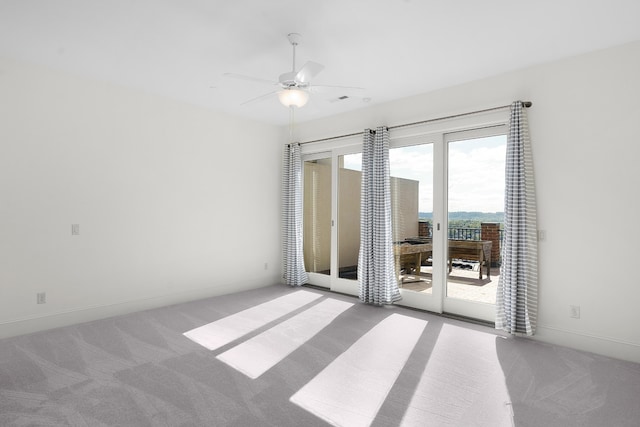 spare room with ceiling fan and light carpet