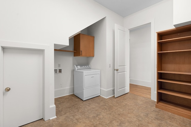 clothes washing area with washer / clothes dryer, light carpet, and cabinets