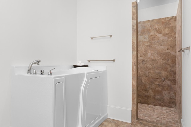 bathroom with tile patterned flooring and tiled shower