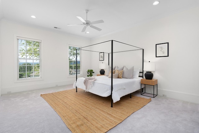 carpeted bedroom with ceiling fan and ornamental molding