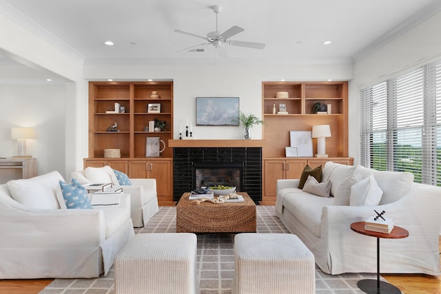 living room with light hardwood / wood-style floors, ceiling fan, and crown molding