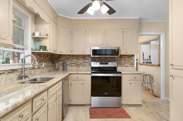 kitchen featuring appliances with stainless steel finishes, ceiling fan, light stone countertops, and sink