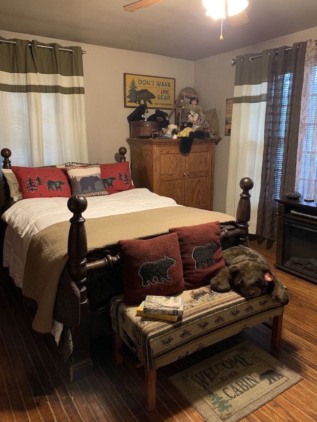 bedroom with dark hardwood / wood-style floors and ceiling fan