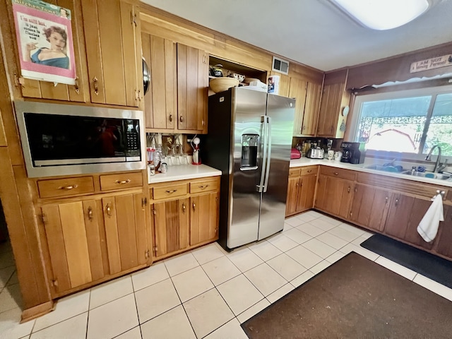 kitchen featuring backsplash, stainless steel appliances, light tile floors, and sink