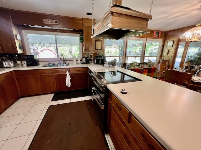 kitchen featuring custom exhaust hood, electric stove, sink, light tile flooring, and pendant lighting