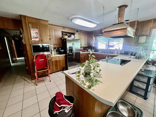 kitchen with a kitchen bar, light tile floors, stainless steel appliances, and ventilation hood