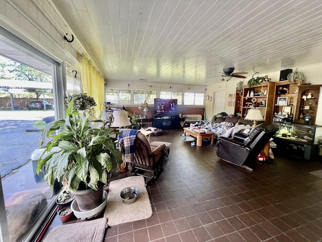 interior space with wooden ceiling, dark tile flooring, and ceiling fan