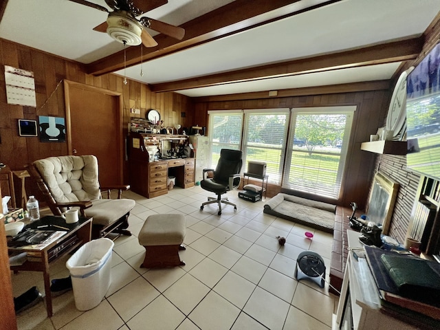 living room featuring beamed ceiling, ceiling fan, wooden walls, and a healthy amount of sunlight