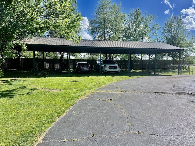 view of parking / parking lot featuring a yard and a carport