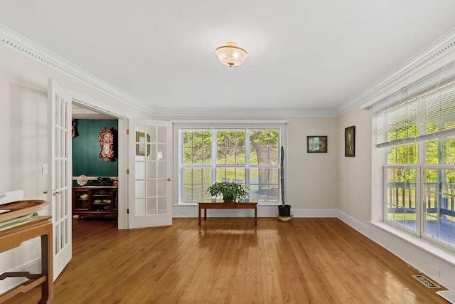 unfurnished room featuring crown molding, french doors, and light wood-type flooring