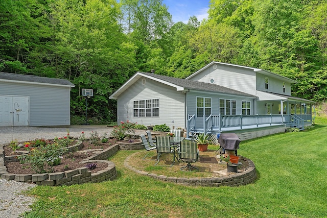 rear view of property with a lawn, a shed, and a wooden deck