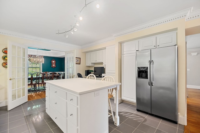 kitchen featuring white cabinets, a center island, stainless steel fridge, and dark wood-type flooring