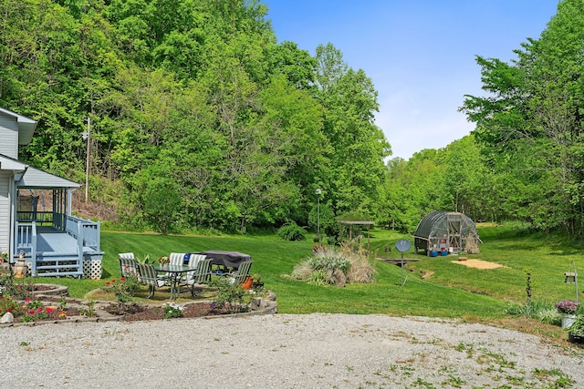 view of yard with a deck and a fire pit