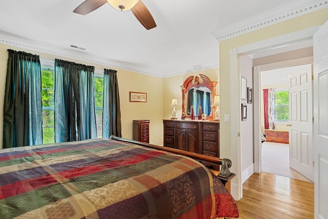 bedroom featuring hardwood / wood-style flooring, ornamental molding, and ceiling fan