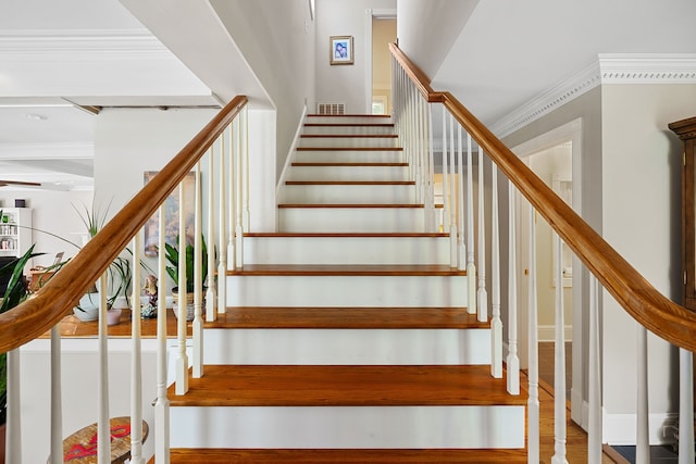 stairway featuring beam ceiling, crown molding, and hardwood / wood-style floors