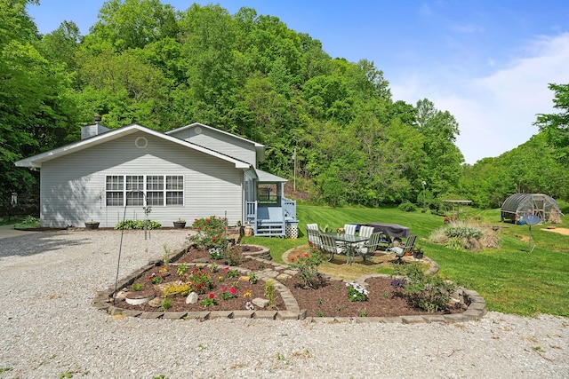 view of front of property featuring an outdoor fire pit and a front lawn