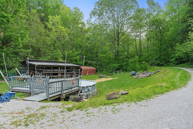 exterior space featuring a front yard, an outbuilding, and a wooden deck