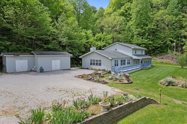 rear view of property with a storage shed, a patio area, and a lawn