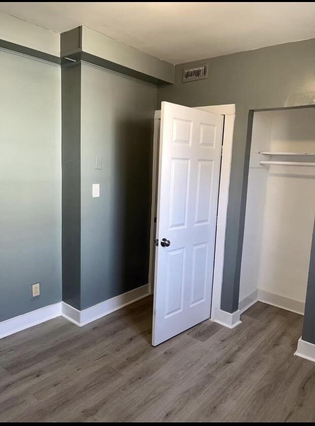 unfurnished bedroom featuring hardwood / wood-style floors and a closet