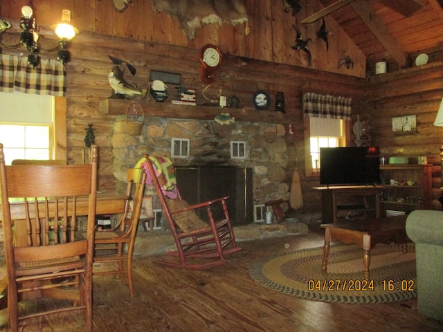 living room featuring wood-type flooring, beam ceiling, high vaulted ceiling, and log walls