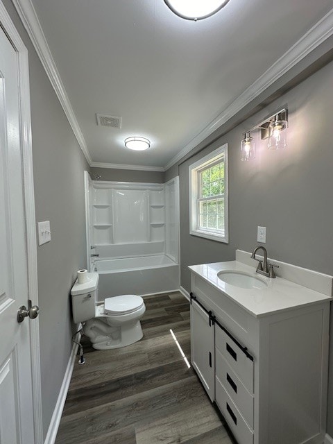 full bathroom featuring shower / bathtub combination, vanity, hardwood / wood-style floors, ornamental molding, and toilet