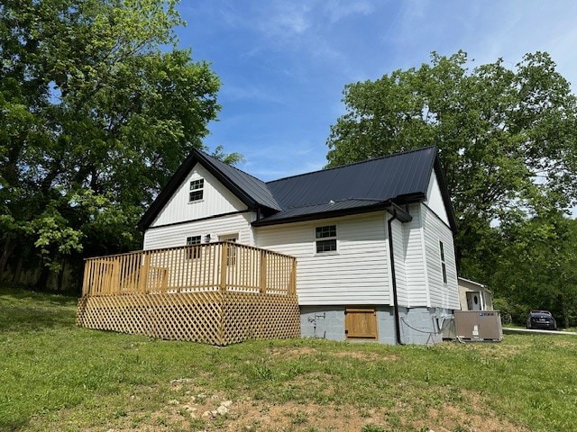 back of house featuring a wooden deck and a yard