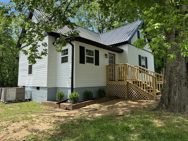 exterior space featuring central AC unit and a wooden deck