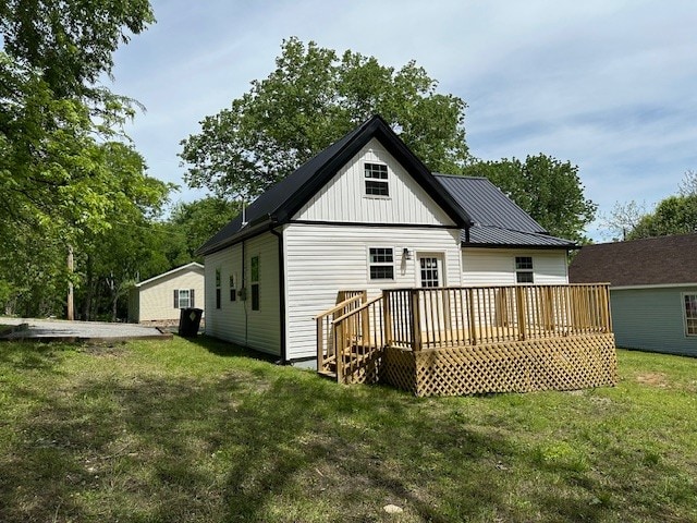 back of property with a deck and a yard