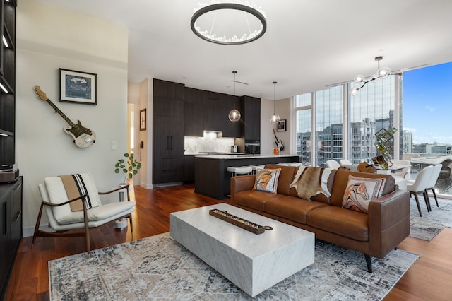 living room featuring floor to ceiling windows, a notable chandelier, and hardwood / wood-style floors