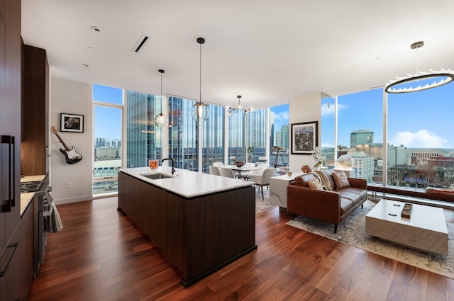 living room featuring a chandelier, a wall of windows, dark wood-type flooring, and sink