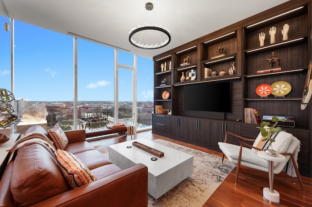 living room featuring expansive windows, a chandelier, and hardwood / wood-style flooring