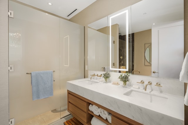 bathroom featuring tile flooring, double sink vanity, and a shower with door