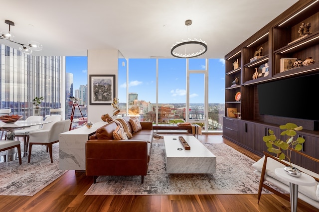 living room with a chandelier, wood-type flooring, and a wall of windows