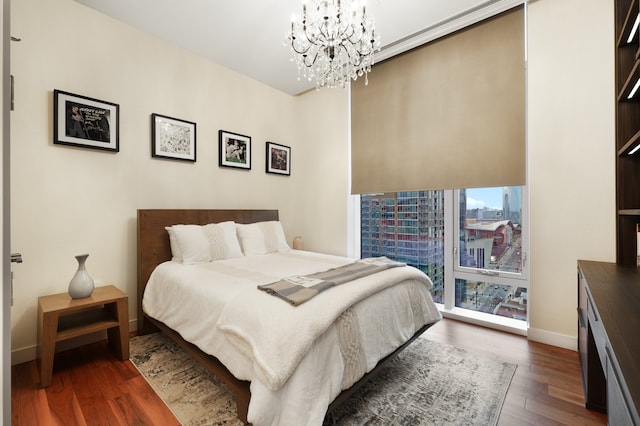 bedroom with dark hardwood / wood-style floors and an inviting chandelier