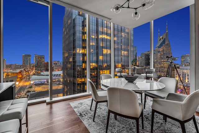 dining space with expansive windows and hardwood / wood-style flooring