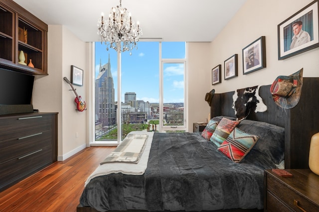 bedroom featuring floor to ceiling windows, hardwood / wood-style flooring, and an inviting chandelier