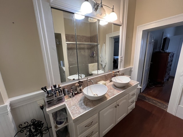 bathroom featuring walk in shower, double vanity, and hardwood / wood-style flooring