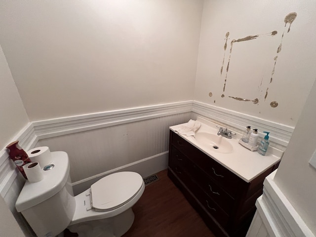 bathroom featuring wood-type flooring, vanity, and toilet