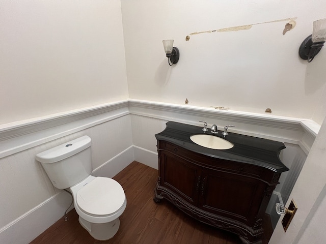 bathroom with hardwood / wood-style floors, toilet, and vanity