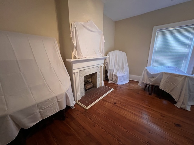 living room with a tile fireplace and dark hardwood / wood-style floors