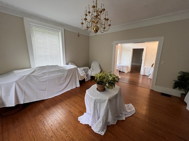 bedroom with a notable chandelier, dark hardwood / wood-style flooring, and crown molding