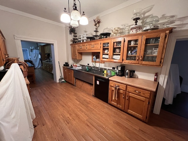 kitchen with crown molding, decorative light fixtures, wood-type flooring, a notable chandelier, and black dishwasher