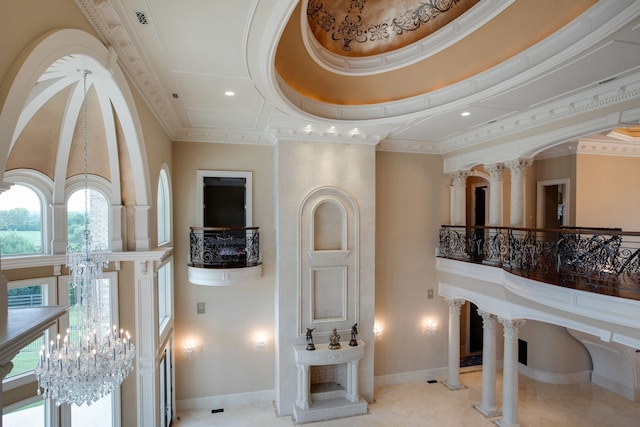 interior space featuring plenty of natural light, ornate columns, tile floors, and an inviting chandelier