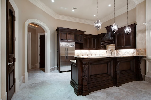 kitchen featuring backsplash, ornamental molding, custom exhaust hood, and stainless steel built in fridge