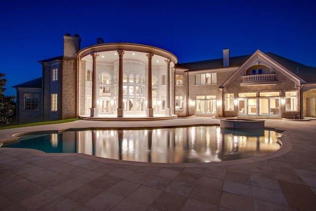 pool at twilight with a patio