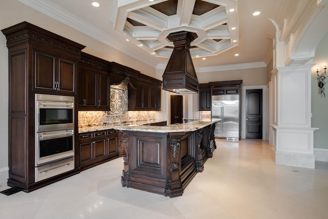 kitchen featuring coffered ceiling, tasteful backsplash, crown molding, stainless steel appliances, and a kitchen island with sink