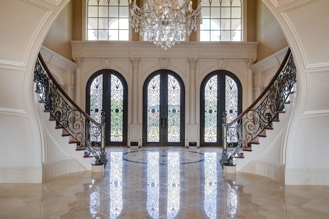 tiled entrance foyer with french doors, a high ceiling, and a wealth of natural light