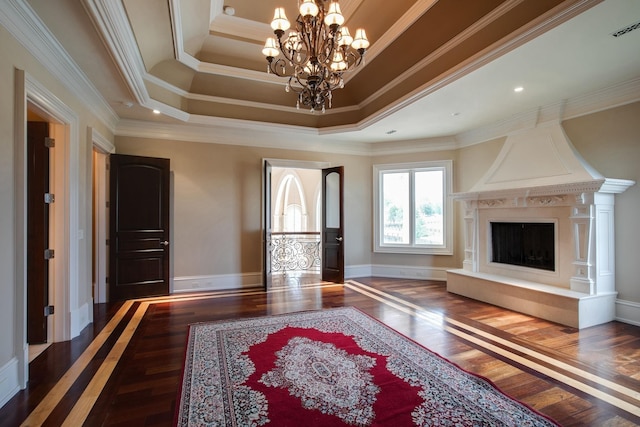 living room with a high end fireplace, dark wood-type flooring, crown molding, and a raised ceiling